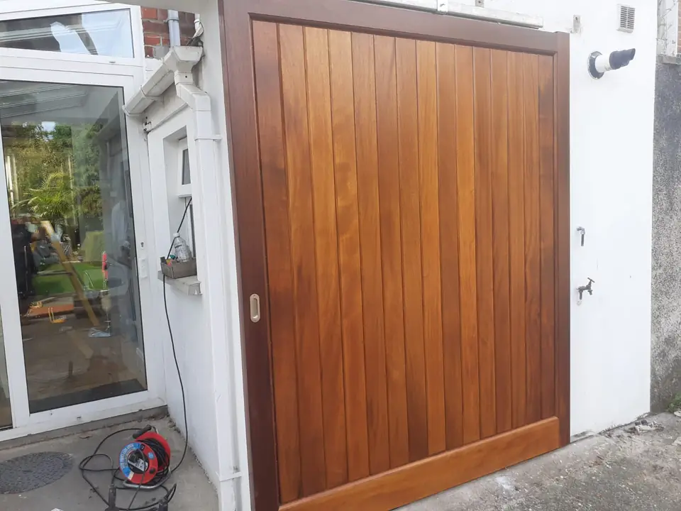 Bespoke natural Iroko hardwood driveway gates made by PJ Gates & Automation