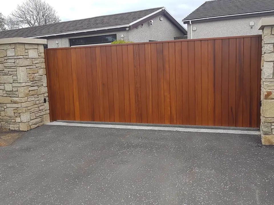 Bespoke natural Iroko hardwood driveway gates made by PJ Gates & Automation
