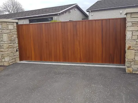 Bespoke natural Iroko hardwood driveway gates made by PJ Gates & Automation