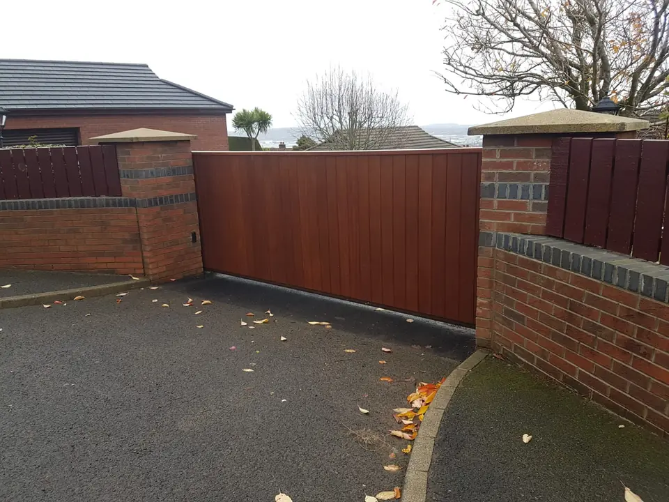 Bespoke natural Iroko hardwood driveway gates made by PJ Gates & Automation