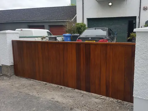 Bespoke natural Iroko hardwood driveway gates made by PJ Gates & Automation